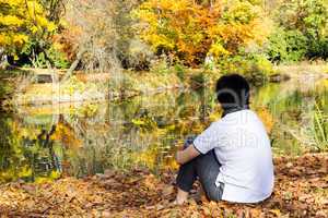 woman sitting in autumn leaves