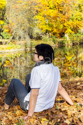 woman sitting in autumn leaves