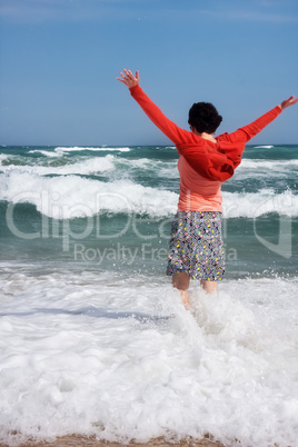 happy woman stands in the sea beach