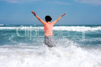 happy woman stands in the sea beach