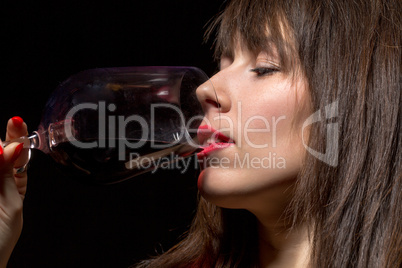 young woman drinking red wine from a glass