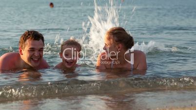 young family splashing in the sea