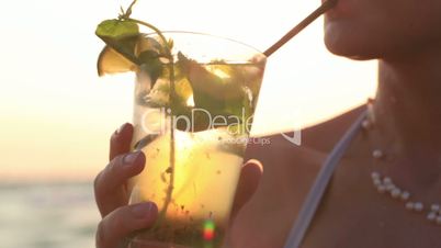 Woman enjoying a tropical mojito cocktail