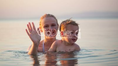 mother and young child waving goodbye