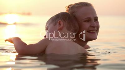 Son and mother embracing in the sea