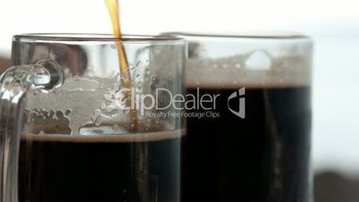 Pouring black beer into the beer cup