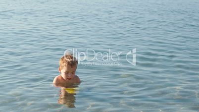 Little boy playing in the shallow sea
