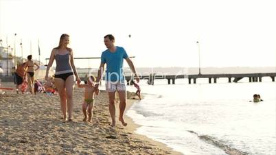 Young couple playing with their son at the seaside