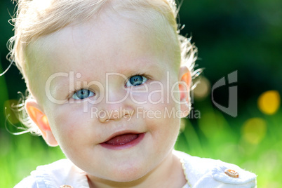 cheerful baby girl on the summer meadow