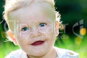 cheerful baby girl on the summer meadow