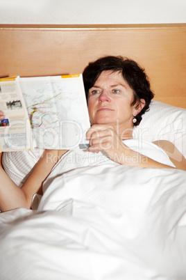 woman is lying in bed reading