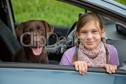 kind und hund in einem auto