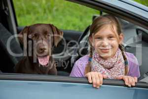 kind und hund in einem auto