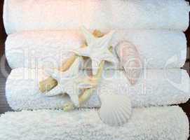 Stack of towels with starfish and shells