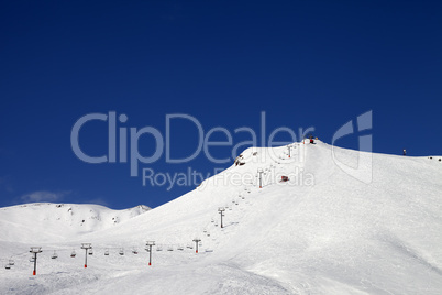 ski slope with ropeway at sun winter day