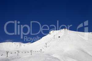 ski slope with ropeway at sun winter day