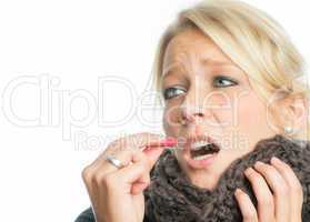 Blonde Frau schluckt Grippekapsel