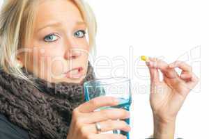 Blonde Frau schluckt Grippekapsel