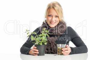 blonde kranke frau mit tee und heilpflanze