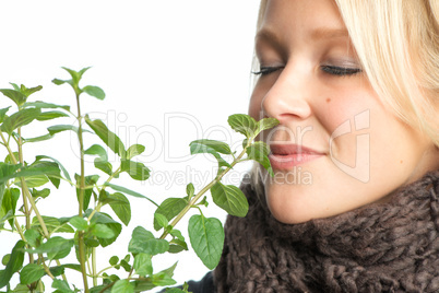 Kranke Frau riecht an Heilpflanze