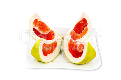 Pomelofrucht in vier Teilen auf einem Teller