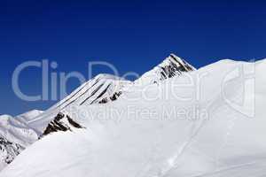 off-piste slope with traces of skis in nice day