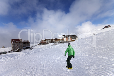 hotels on ski resort and snowboarder on slope