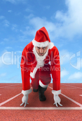 Santa Claus in the starting position on a running track