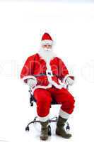 Young Santa Claus sitting on an office chair.