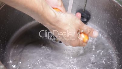 Closeup of hands washing carrot