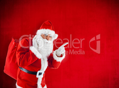Santa Claus with sack pointing in blank red