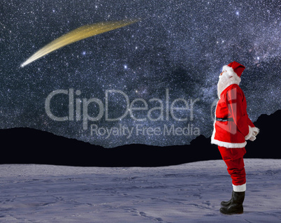 Santa Claus looks at the sky with a shooting star