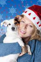 Woman with christmas hat hugging her jack russell