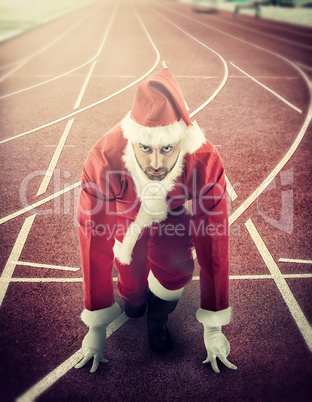 Santa Claus in the starting position on a running track
