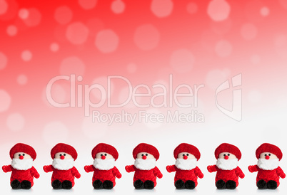 Row of puppets of Santa Claus on a red background with snow