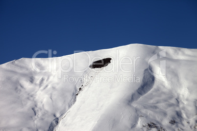 trace of avalanche on off-piste slope in sunny day