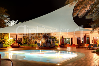 the swimming pool at luxury hotel in night illumination, ajman,