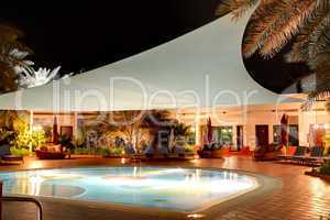 the swimming pool at luxury hotel in night illumination, ajman,