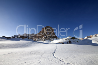 snowy plateau and footpath against rock and blue sky in nice day