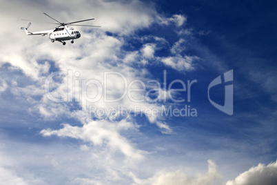 helicopter in blue sky with clouds