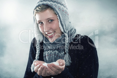junge glückliche frau mit einer hand voll schnee