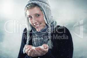 junge glückliche frau mit einer hand voll schnee