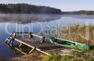 foggy lake with bridge and boat