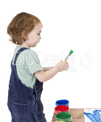 child with brush and green paint