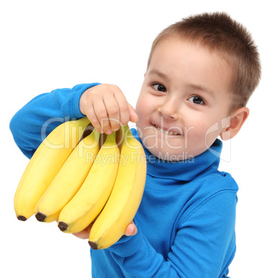 little boy holds bananas