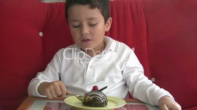 child eating cake and smiling to camera