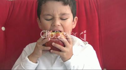 child eating red apple