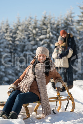 young woman sitting winter wooden sledge