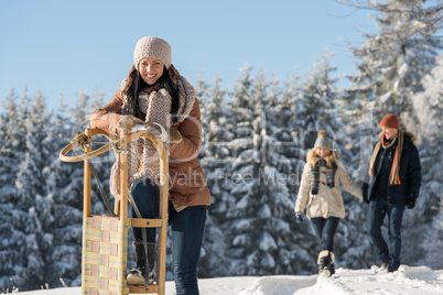 young woman sunny winter lean against sledge