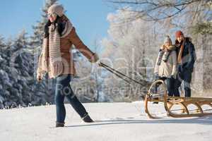young woman pulling winter sledge snow countryside
